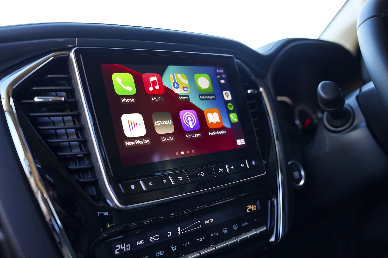 Car infotainment screen showing Apple CarPlay apps (Phone, Music, Maps, Messages) in a vehicle dashboard.