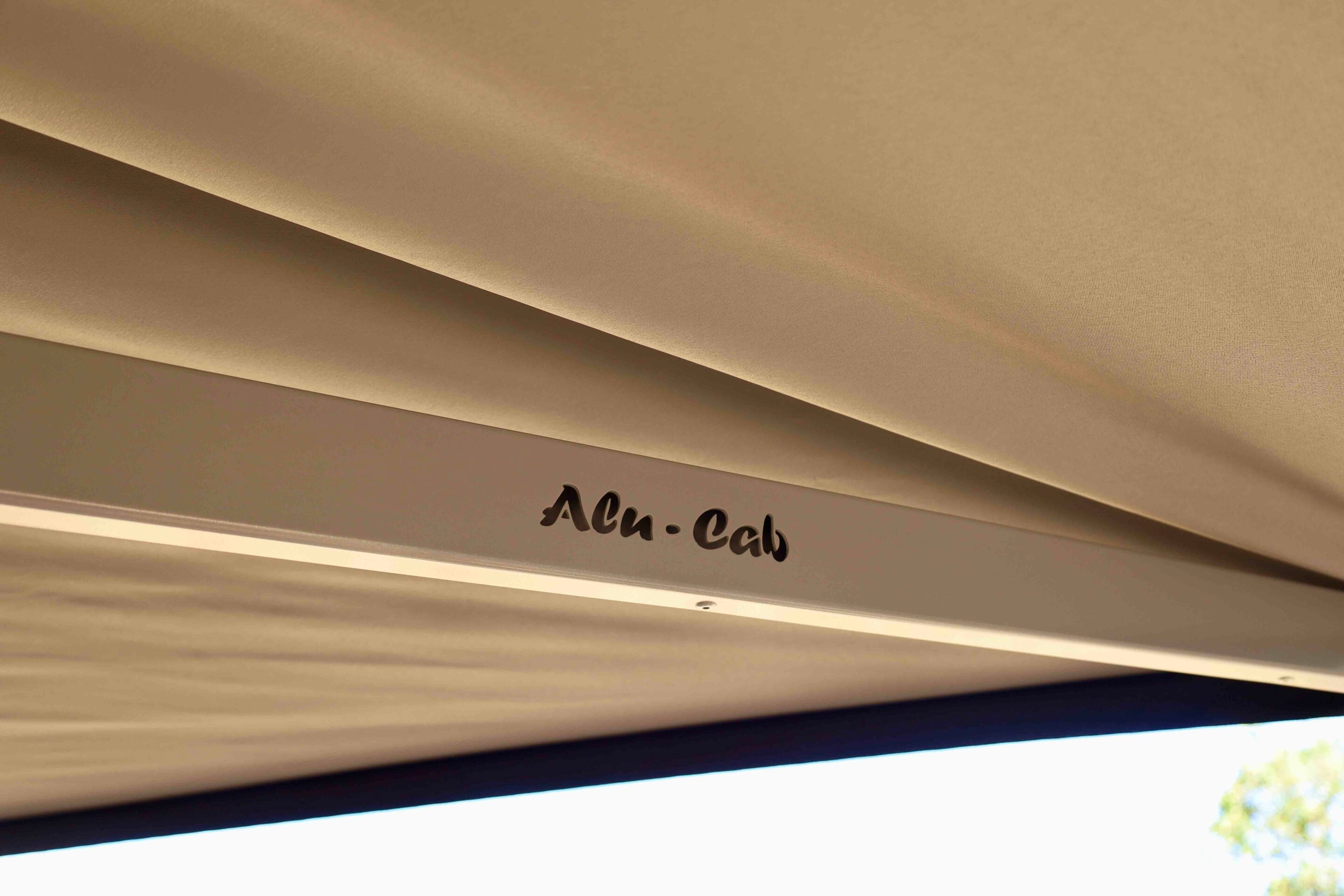 Close-up of a beige ceiling with soft folds and a partial sign that reads 'Alex' in dark lettering beneath it.
