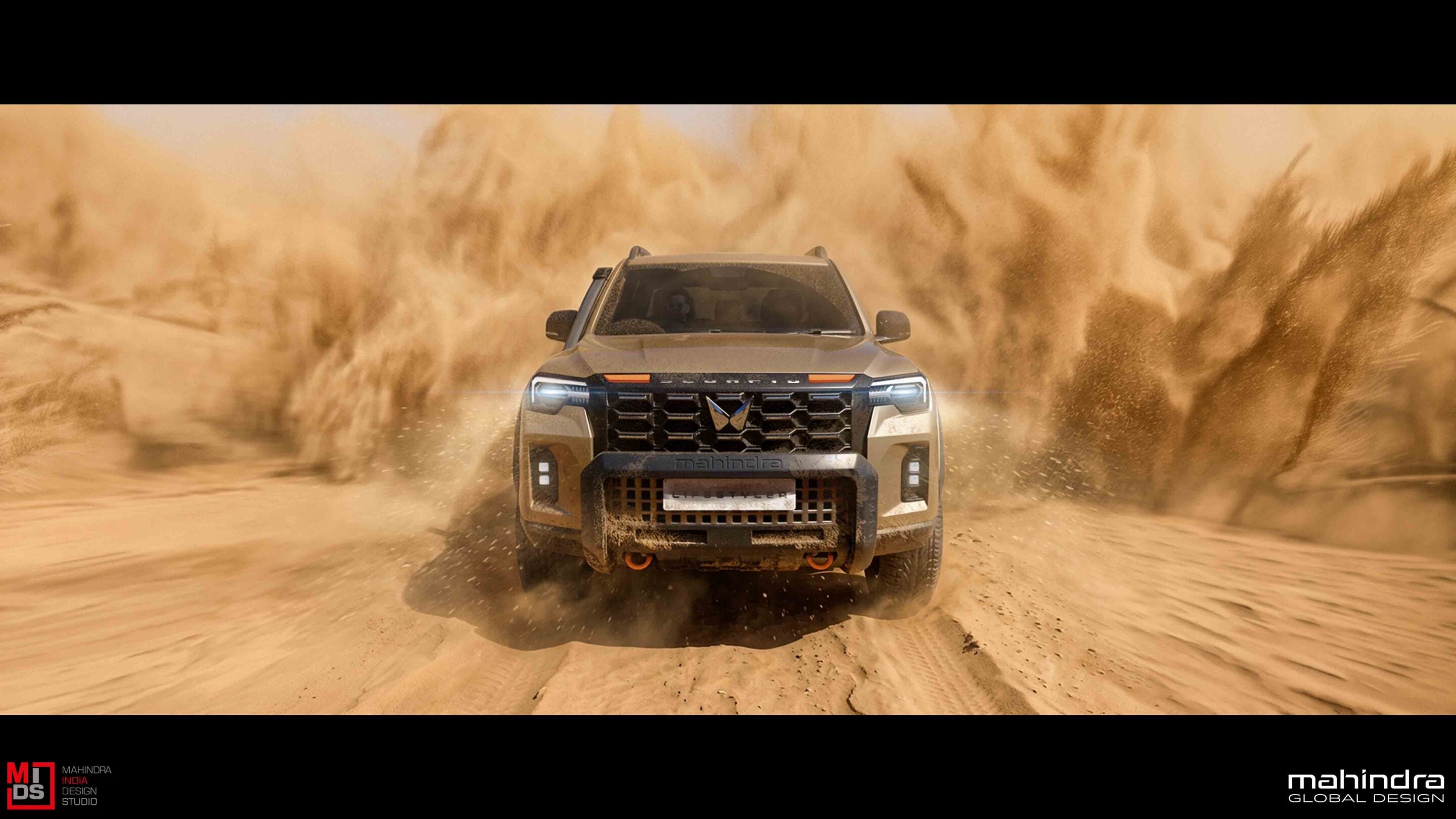 Front view of a Mahindra off-road SUV kicking up sand as it drives through a desert.
