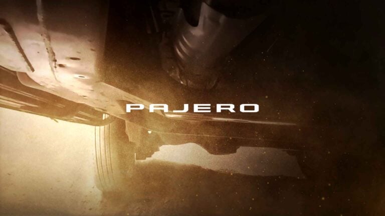 Sepia-toned shot of a vehicle’s undercarriage with the bold white word PAJERO across the center or the logo overlaid on the scene.