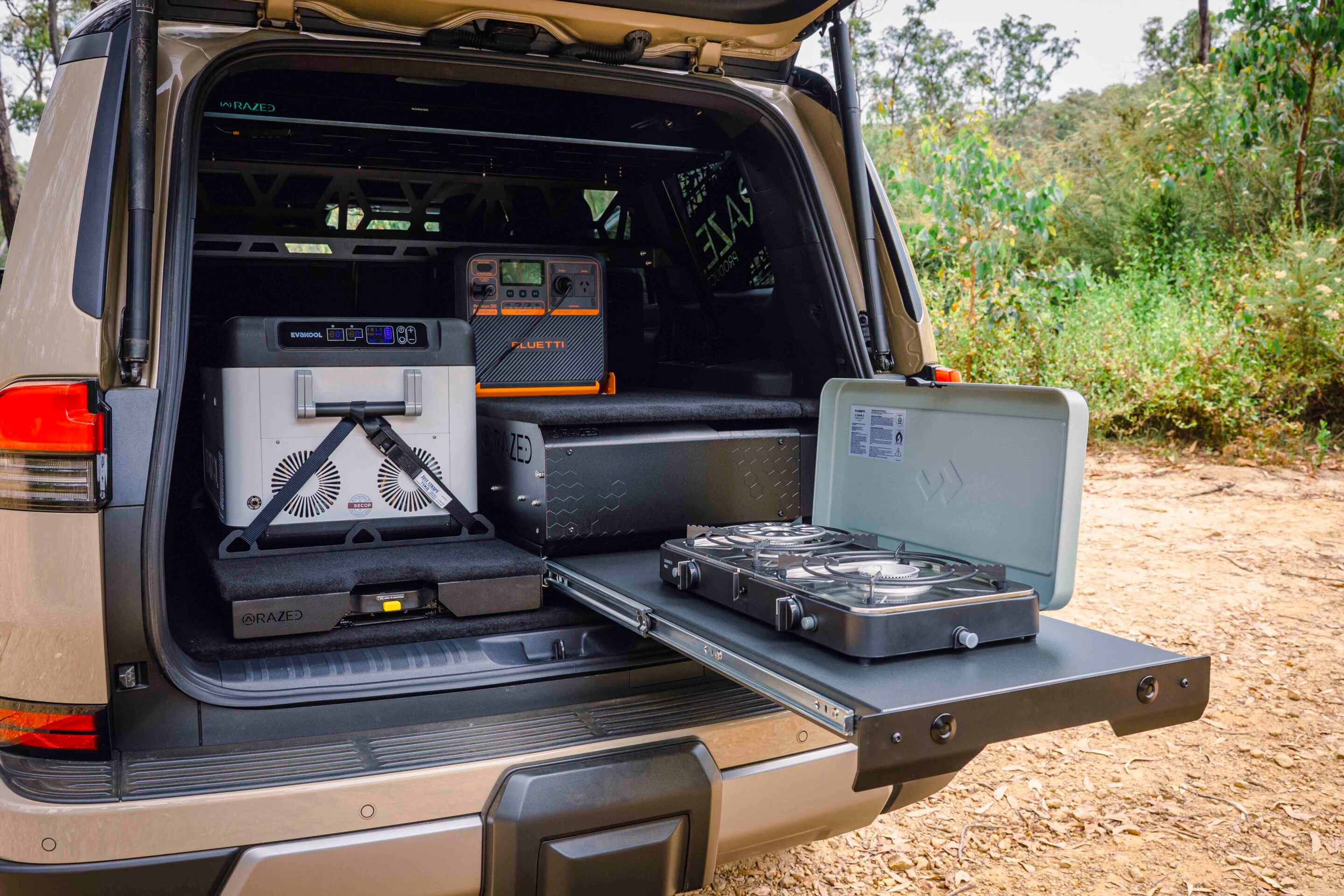 Open SUV trunk with portable power equipment: generators, batteries, and cables organized in the cargo area for off-grid power.