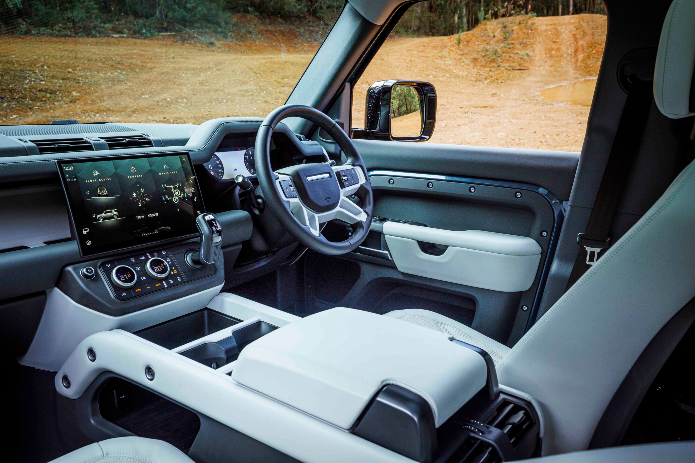Interior view of a modern car cabin with a large touchscreen infotainment display and steering wheel visible at center