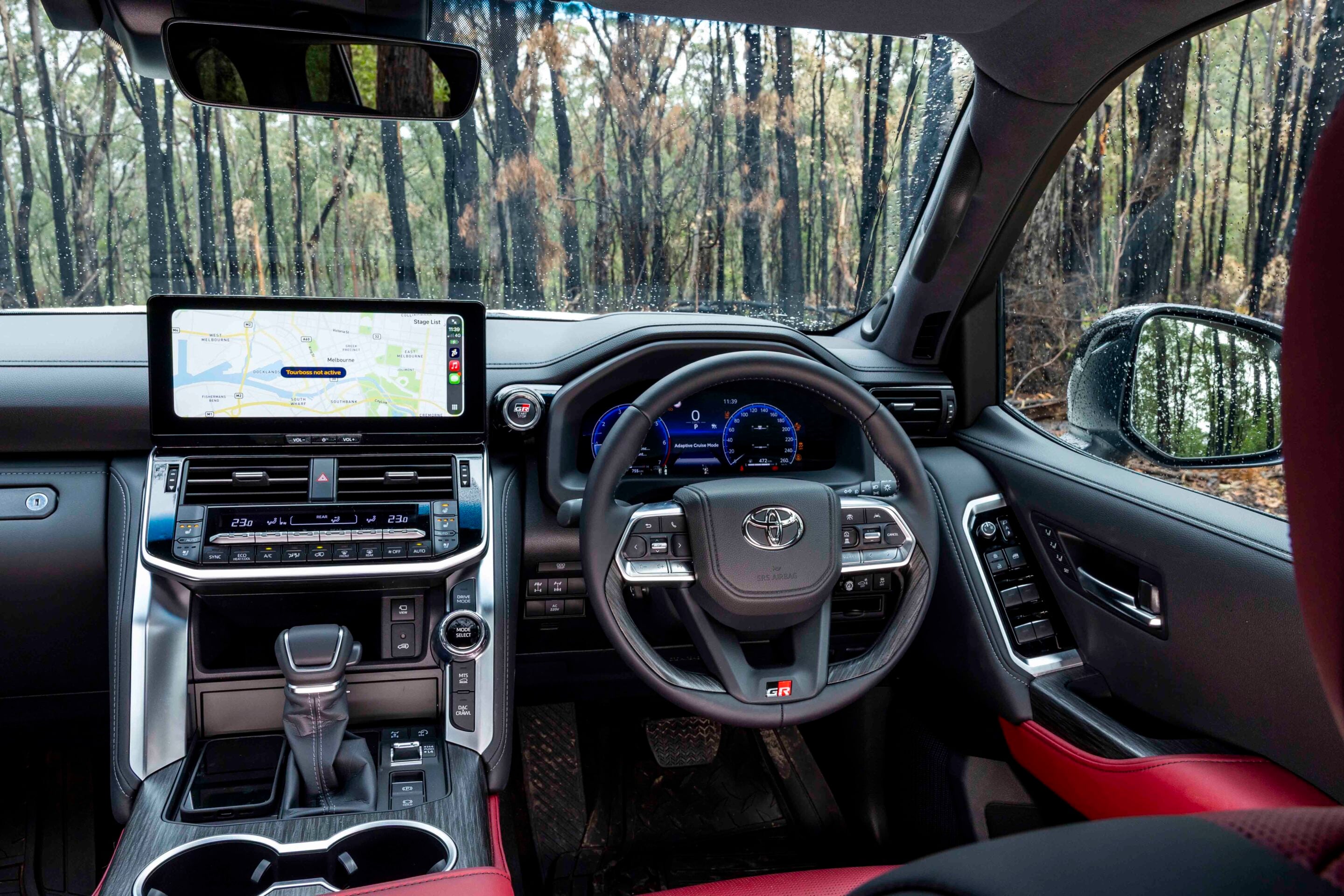 Car interior with a navigation touchscreen, gear shifter, and steering wheel visible.