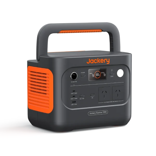 Portable power station with handle, dark gray body, orange vents, and Jackery Explorer branding; shows outlets and display panel (solar generator).