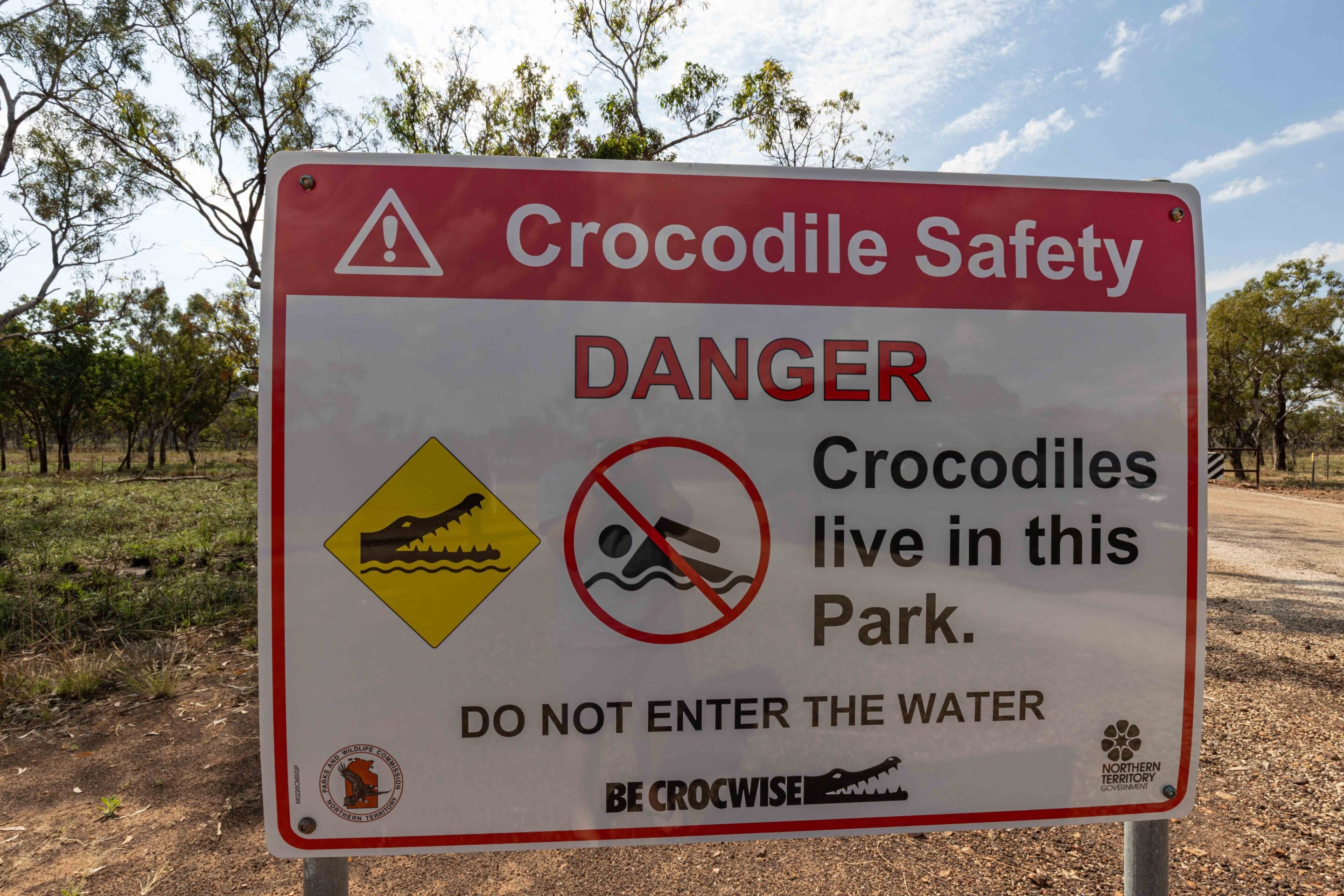 Warning Crocodile Safety sign: danger text with crocodile/water symbols, advising not to enter the water in this park.