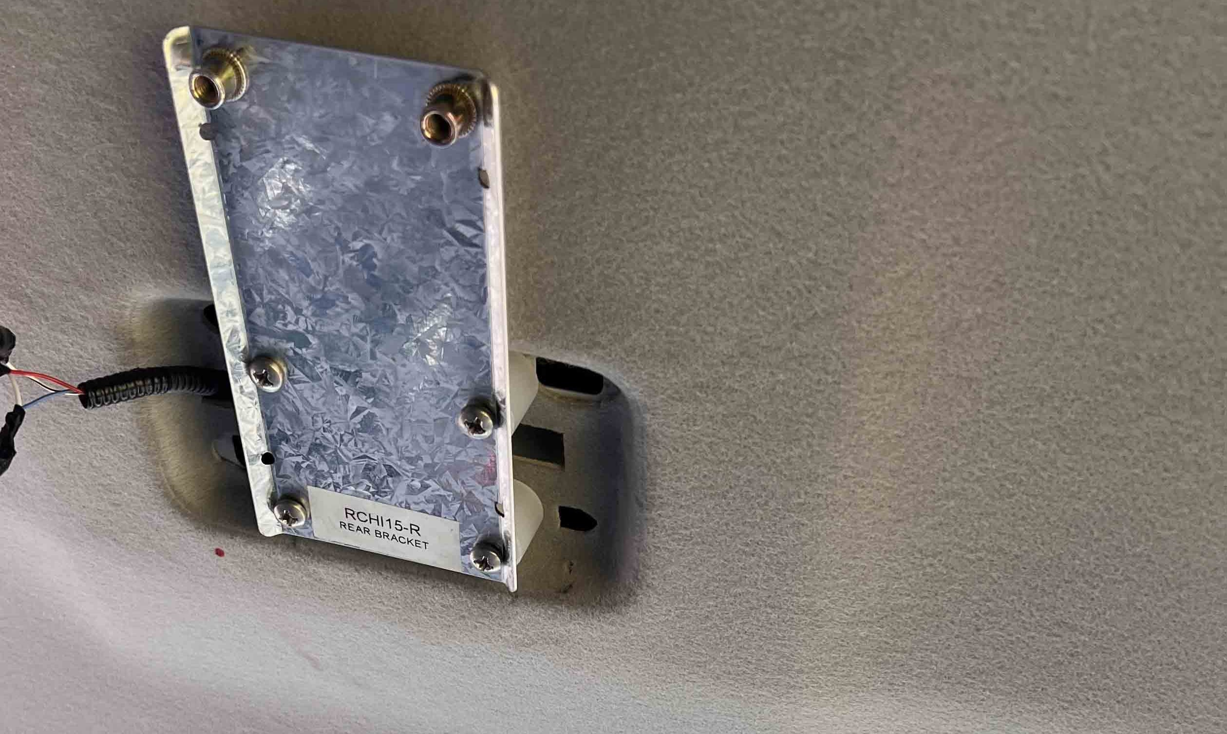 Metal Specimen: galvanized rear bracket with bolts mounted to a surface, label reads 'RCH15-R REAR BRACKET'