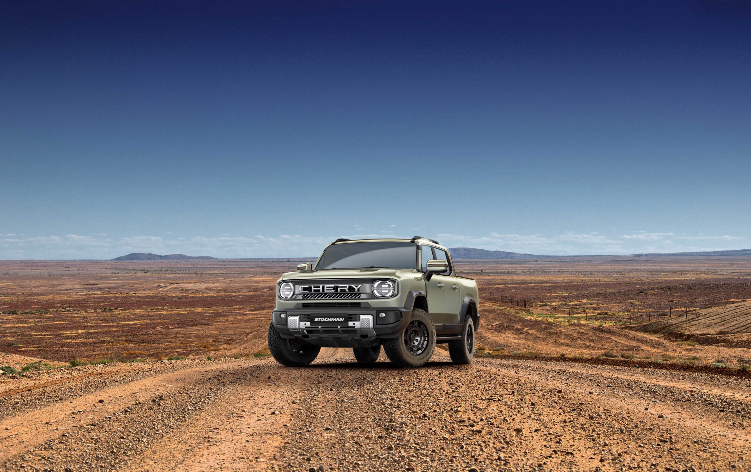 Silver Chery Stockman pickup truck in a flat desert landscape under a clear blue sky at horizon level.
