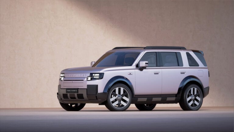 Silver SUV (Land Rover Freelander 2) photographed from a front-left angle in a studio setting, showing the grille and headlights.
